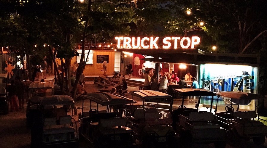 Commercial truck parked at a truck stop while the driver walks toward a restaurant or rest area