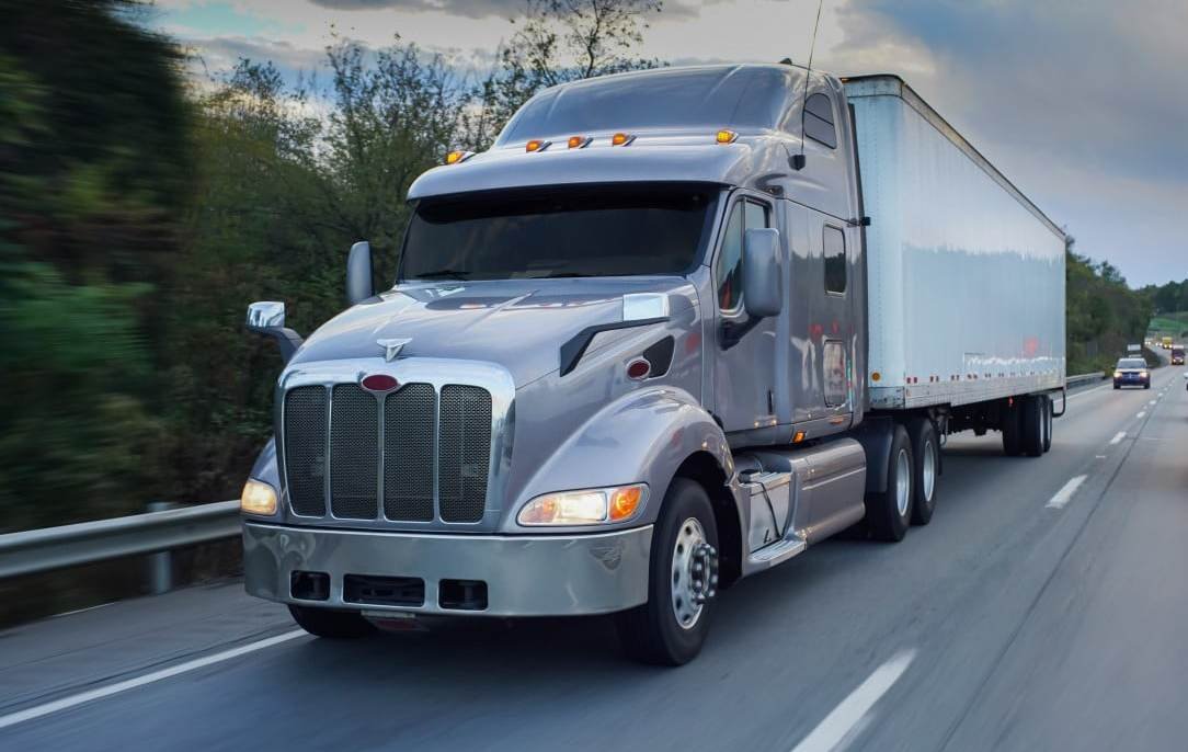 Semi truck and trailer on the highway representing a common Class A CDL vehicle