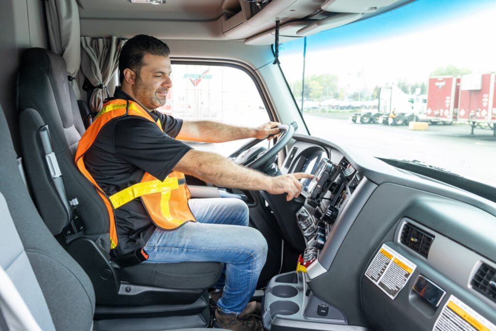 Truck driver resting in a parked semi truck while reviewing ELD or logbook entries