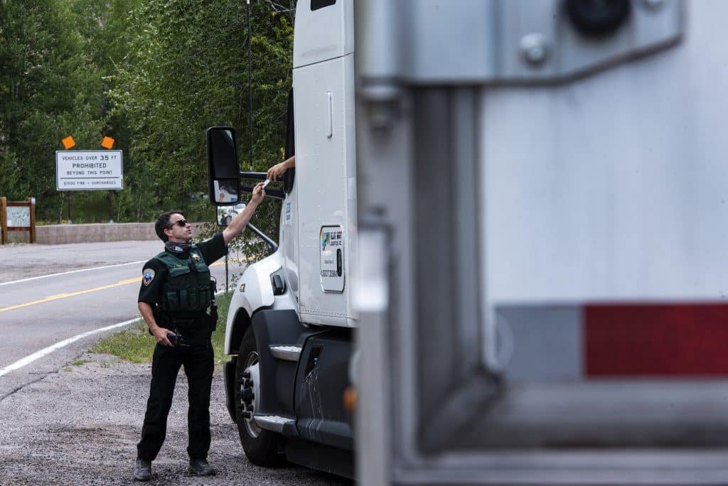 Commercial vehicle inspector reviewing paperwork with a California truck driver