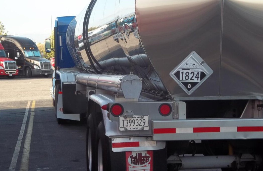Hazmat tanker truck displaying hazardous materials placards